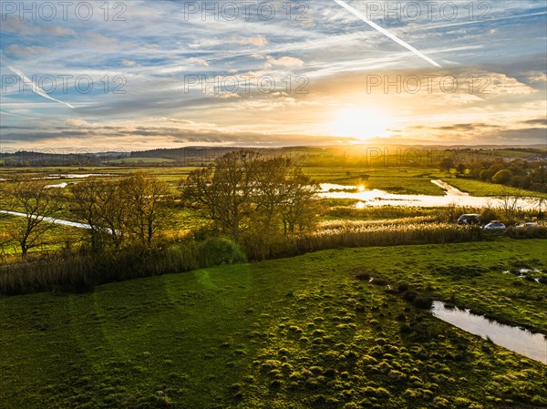 Sunset over Wetlands and Marshes in RSPB Exminster and Powderham Marshe from a drone