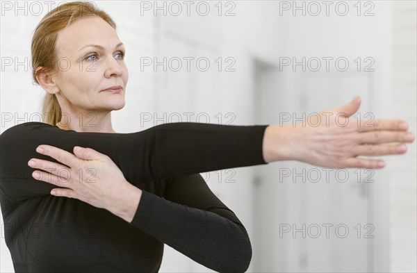 Medium shot woman stretching arm