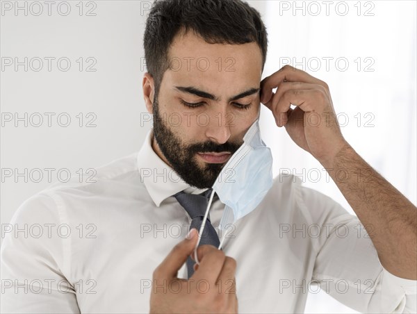 Doctor taking off his medical mask