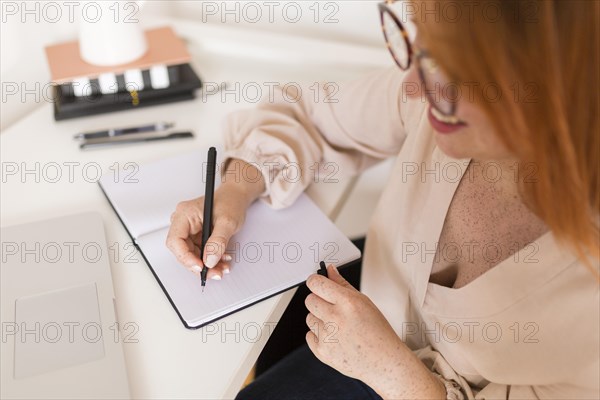 Female teacher desk writing agenda during online class