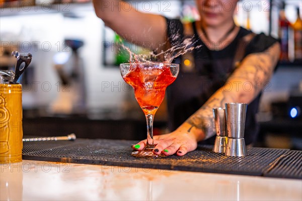 Cropped close-up photo of an unrecognizable bartender preparing a cocktail in the bar