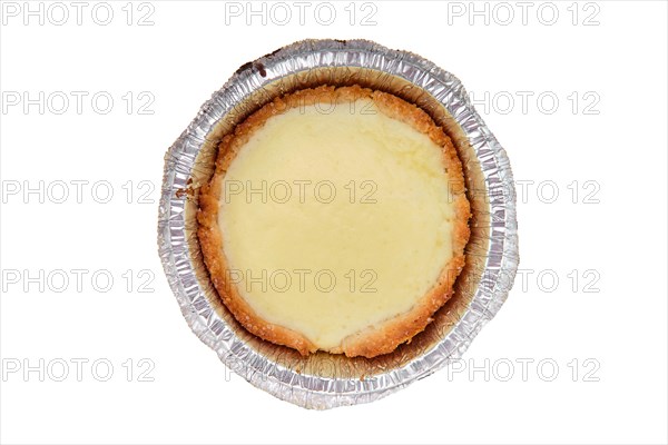 Top view of vanilla cake in a baking foil dish isolated on white background