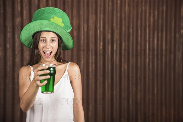 Crying young woman showing glass drink