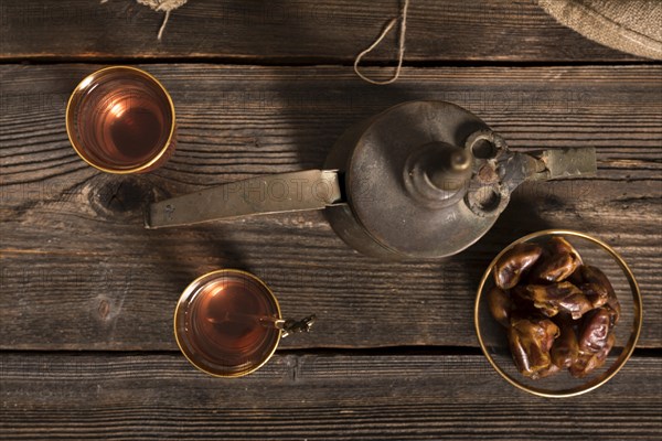 Dates fruit with tea glasses wooden table