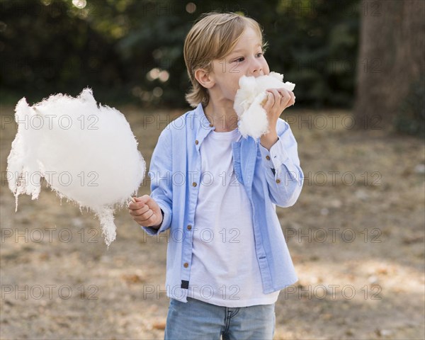 Medium shot kid eating cotton candy