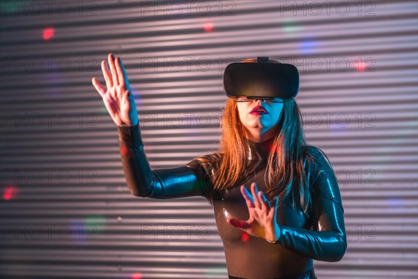 Futuristic woman using Virtual reality goggles in an urban night space with neon lights