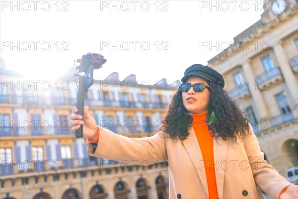 Blogger recording a video while travelling in a beauty city in a sunny day of autumn