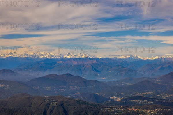 Aerial View over a Beautiful Mountainscape and And Snow Capped Mountain and with Floating Clouds in a Sunny Day in Lugano