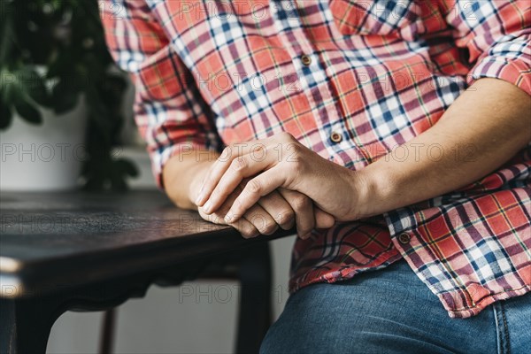 Close up man s clasped hand wooden table