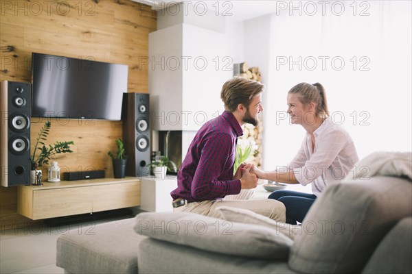 Couple holding hands couch