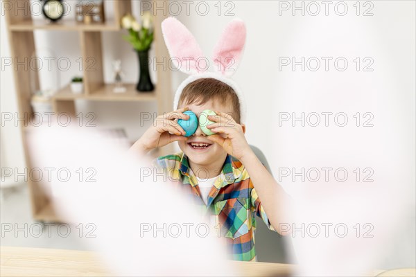 High angle little boy playing with eggs