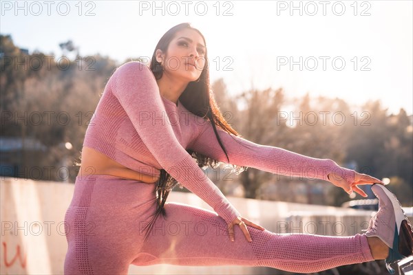 Woman stretching the leg in an urban park in the morning