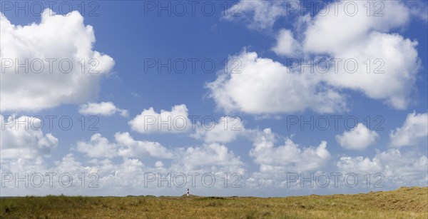 Dune landscape and lighthouse with blue sky at Ellenbogen