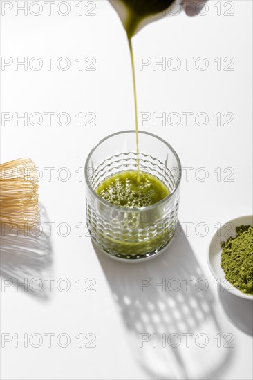 Close up matcha tea pouring into glass