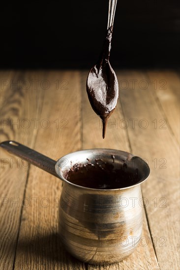 High angle teaspoon with melted chocolate pot