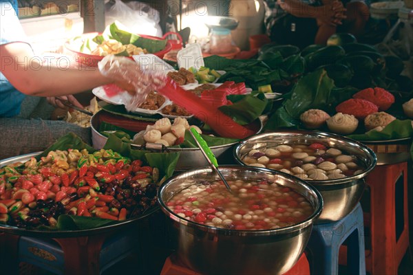 Authentic local khmer desserts sold in the traditional Samaki Market in Kampot Cambodia showing the candid daily life