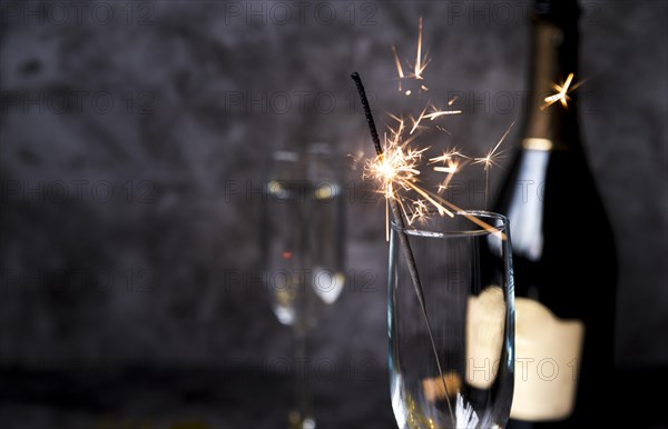 Burning sparkler transparent wine glass