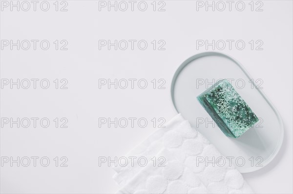 High angle view green soap bar napkin white backdrop