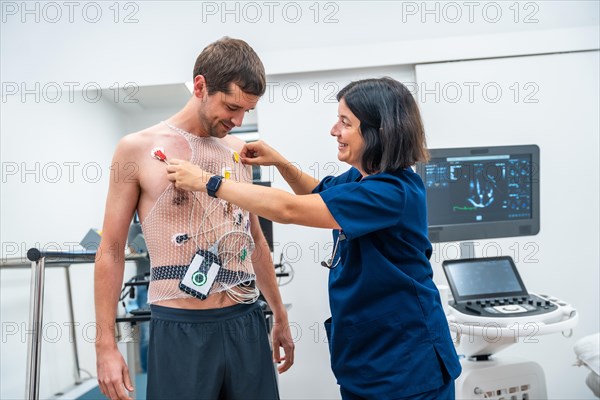 Female doctor putting the mesh and devices for the stress test cardiology test in the clinic