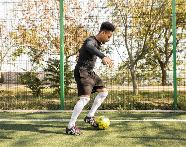 African american man playing with soccer ball