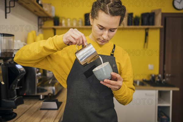 Front view barista pouring milk coffee