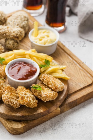 High angle fried chicken legs nuggets with fizzy drinks french fries