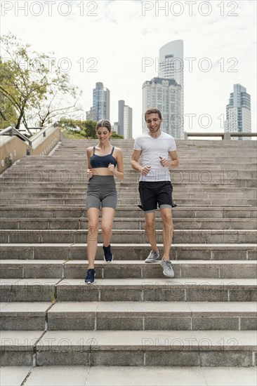 Front view man woman exercising stairs