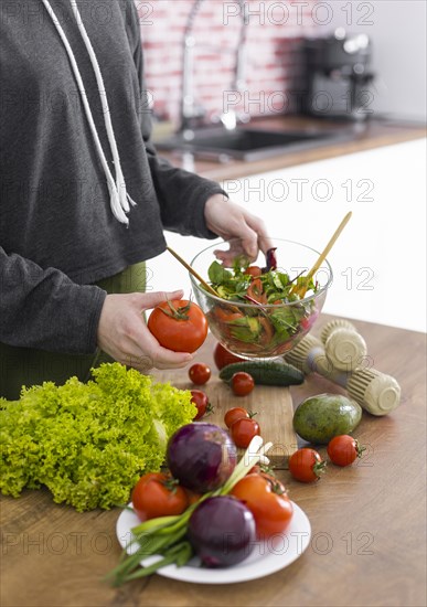 Close up hand holding bowl with tasty salad