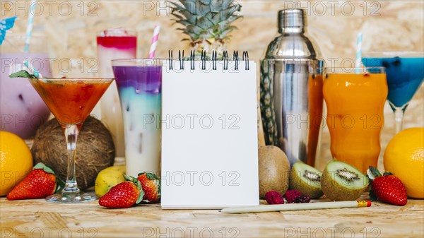 Cocktail tropical fruits with blank notepad