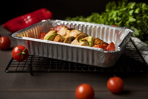 High angle chicken skewers tray with red pepper cherry tomatoes
