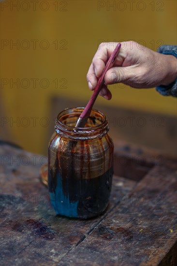 Senior expert violin maker luthier varnish with brush classic handmade violin paint natural ingredient recipe in Cremona Italy home of best artisan of this kind