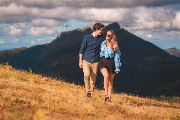 Lovers strolling along a hill in the mountain in a sunny day in the morning