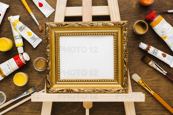 Empty canvas golden frame paint flat lay