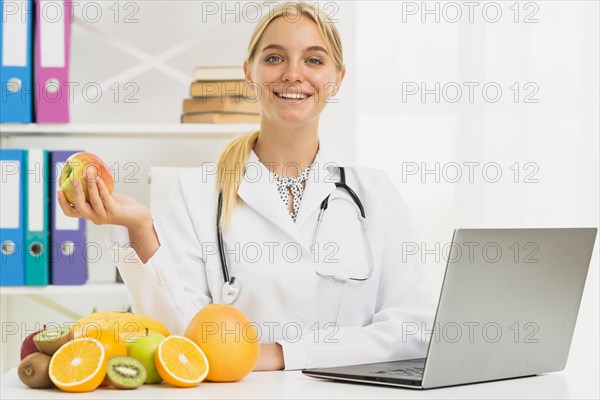 Medium shot smiley nutritionist with apple