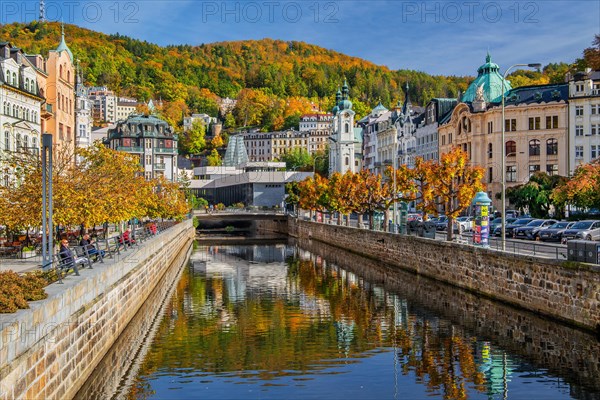 Tepla River in the town centre with the spa colonnade and the Church of St. Mary Magdalene in autumn