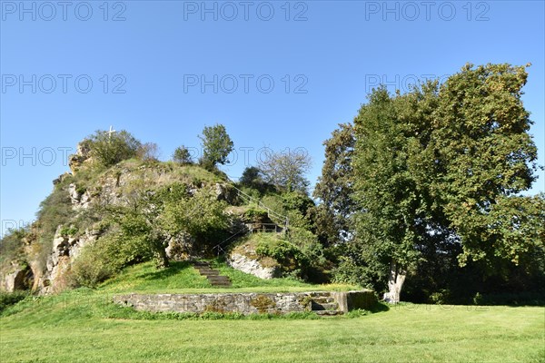 Rocky spur with summit cross on the site of the Hunolstein castle ruins