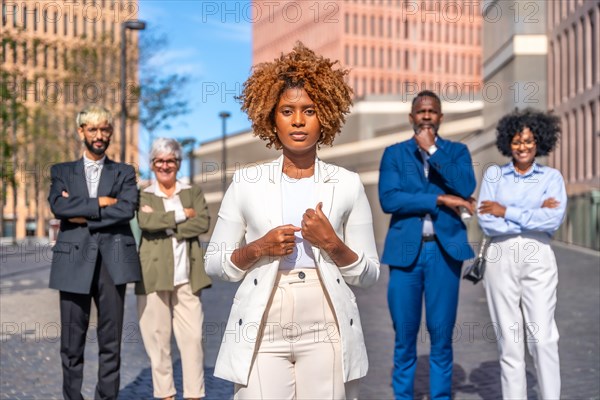 Frontal photo of an african businesswoman standing serious next to colleagues