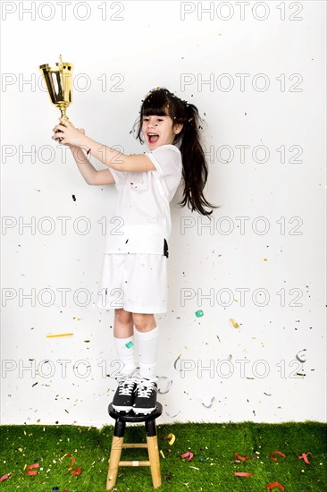 Football concept with girl celebrating with trophy