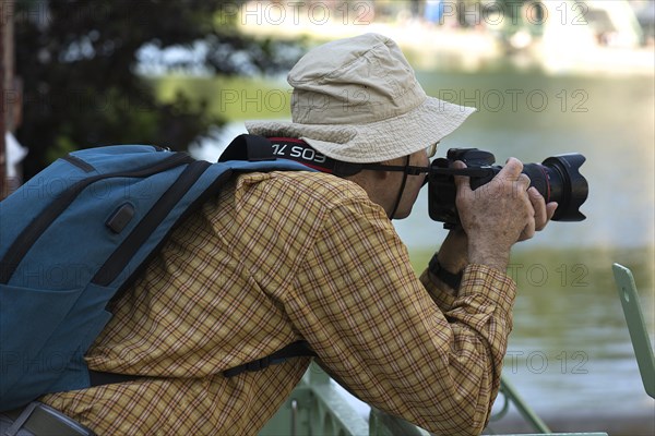 Elderly gentleman with hat taking a picture