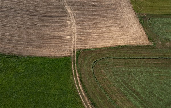 Drone view of green and ploughed fields with field path near Pabneukirchen