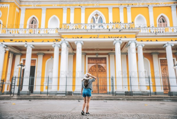 Rear view of tourist girl looking at cathedral. Tourist woman from back looking at a cathedral in a square. Granada