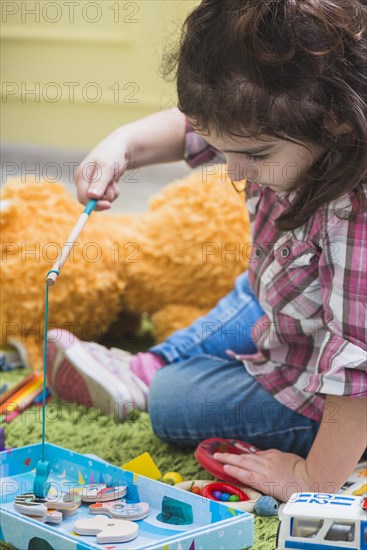 Girl playing with toy fishing rod