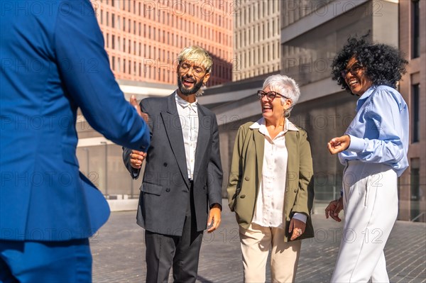 Multi-ethnic group of business people shaking hands when arrive to a meeting point outside a financial building