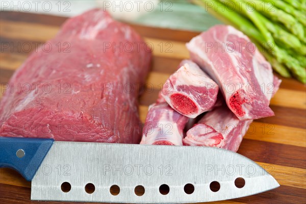 Raw beef and pork ribs with asparagus and herbs ready to cook