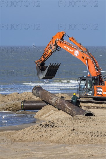 Hydraulic excavator installing pipeline during sand replenishment