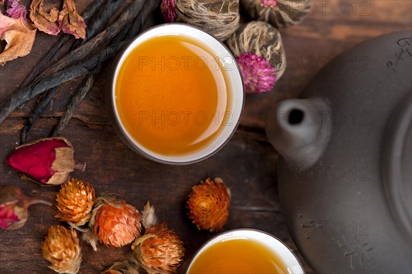 Chinese style herbal floral tea over wood table with raw ingredients