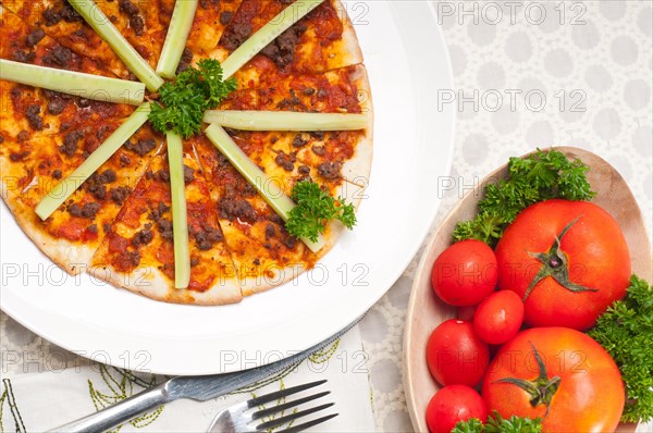 Fresh baked Turkish beef pizza with cucumber on top