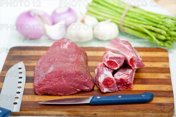 Raw beef and pork ribs with asparagus and herbs ready to cook