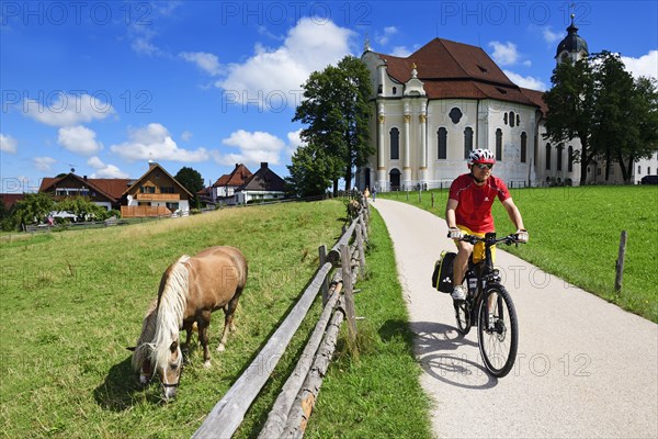 Cyclist with touring bike in front of the Wieskirche