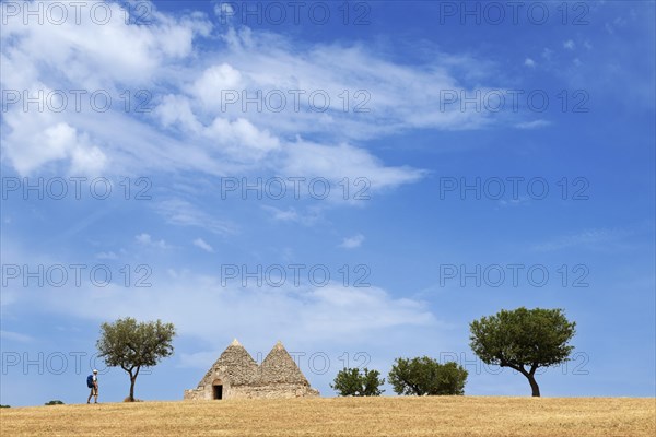 Hikers between trulli near Noci and Alberobello